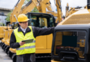 inspector with tablet looking at construction machine