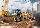 Wheel loader and crawler crane working in an urban construction site.