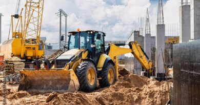 Wheel loader and crawler crane working in an urban construction site.